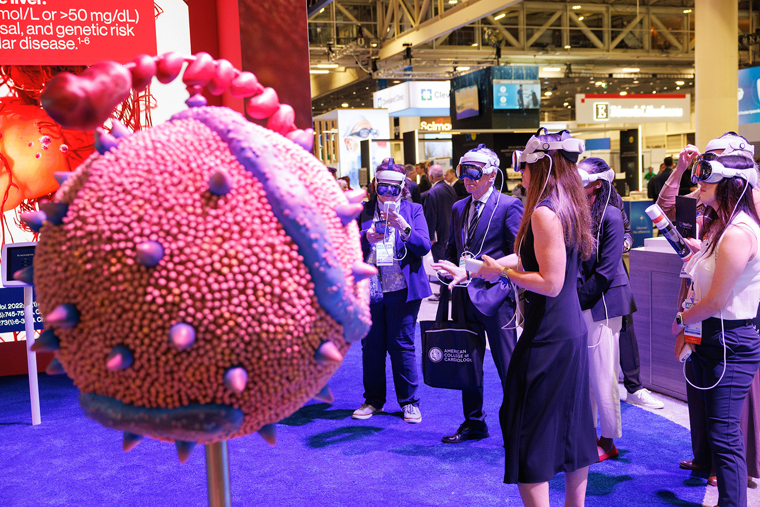 Attendees at ACC.26 exploring technology in an exhibitor booth wearing virtual reality goggles.